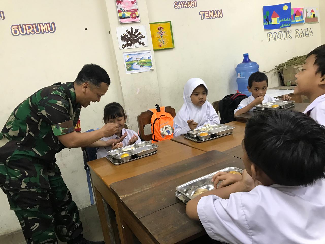 Tidak Menyia-nyiakan Kesempatan, Babinsa Kepatihan Wetan Jalin Keakraban Dengan Murid Disela-sela Pembagian Makanan Bergizi Gratis