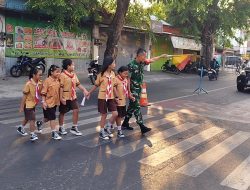 Jaga Keselamatan Anak, Babinsa Koramil 04/Jebres Dampingi Siswa SD Menyeberang Jalan