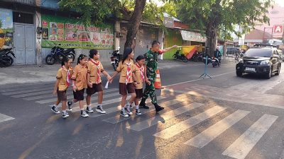 Jaga Keselamatan Anak, Babinsa Koramil 04/Jebres Dampingi Siswa SD Menyeberang Jalan